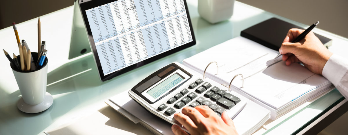 A close-up of a professionalās hands using a tablet or computer with visible invoice or payment data on the screen