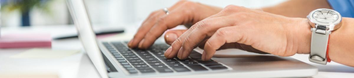 cropped view of businesswoman typing in laptop