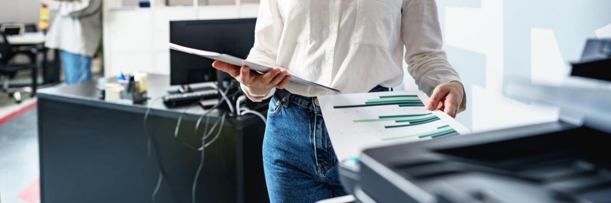 employee picking up print job at printer